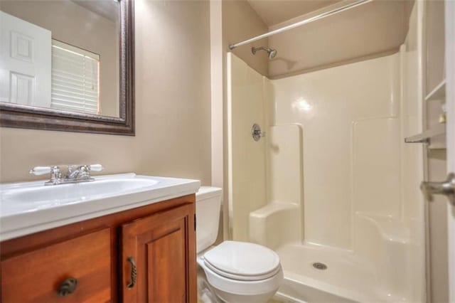 bathroom with vanity, walk in shower, and toilet