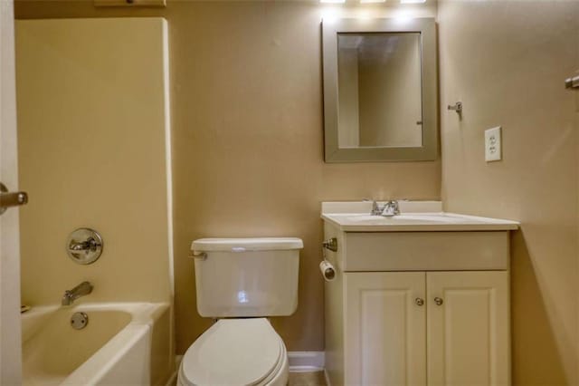 bathroom featuring washtub / shower combination, vanity, toilet, and baseboards