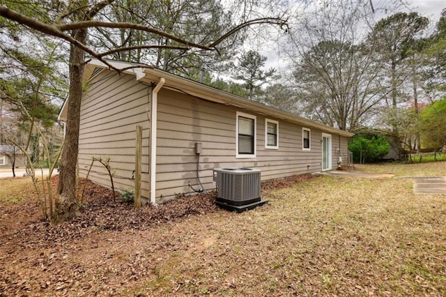 view of side of property with a lawn and central AC unit