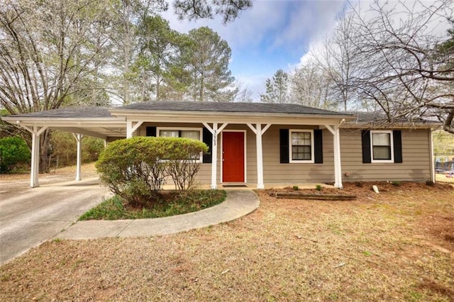 ranch-style home featuring driveway, an attached carport, and a front yard