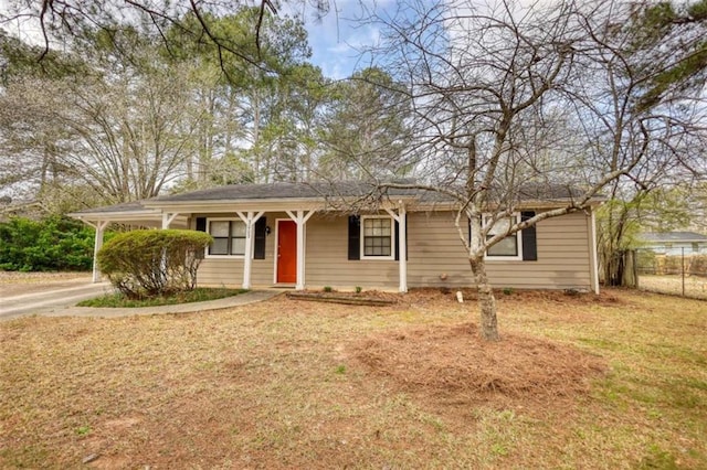 ranch-style home featuring a front lawn and fence