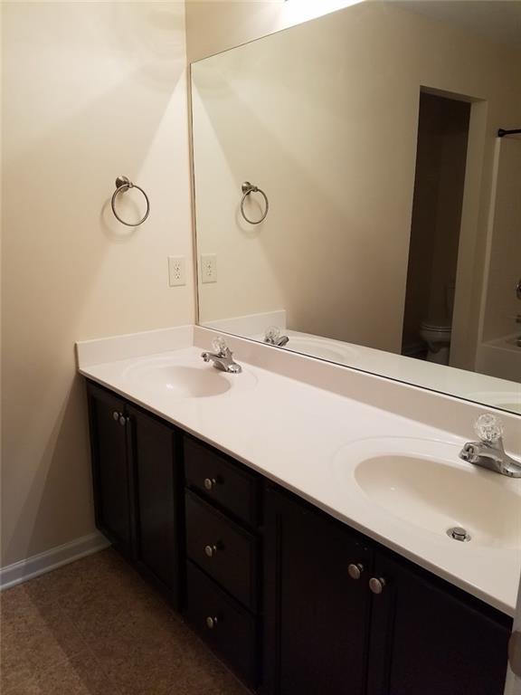 spare room with a tray ceiling, dark wood-type flooring, and ceiling fan