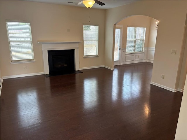 unfurnished living room with dark wood-type flooring and ceiling fan