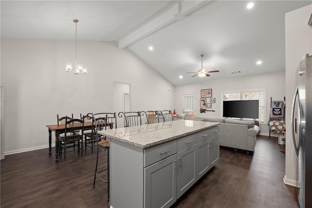 kitchen featuring a breakfast bar, a kitchen island, pendant lighting, and dark hardwood / wood-style floors