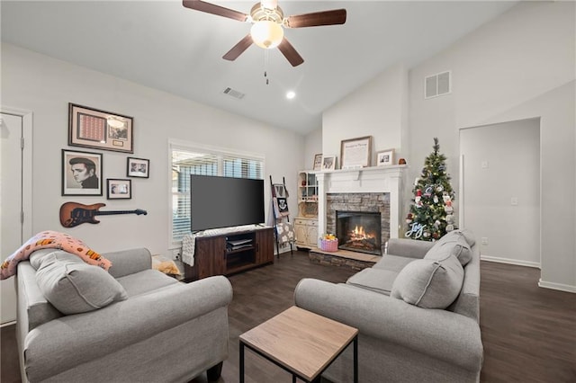 living room with dark hardwood / wood-style floors, a stone fireplace, ceiling fan, and lofted ceiling