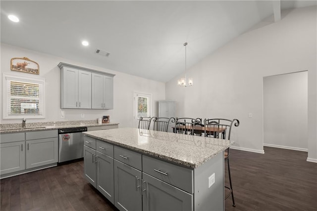 kitchen with dark wood-type flooring, plenty of natural light, a kitchen island, and stainless steel dishwasher