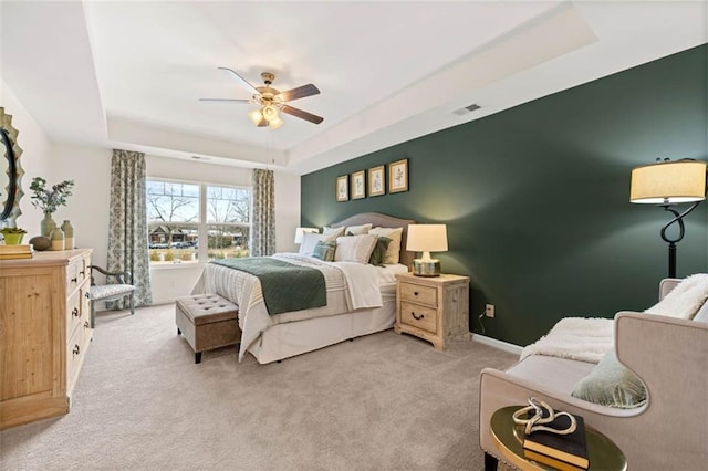 353 Sound Cir, Stockbridge, GA 30281 - bedroom featuring light carpet, a tray ceiling, visible vents, baseboards, and a ceiling fan