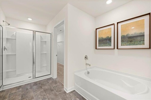 353 Sound Cir, Stockbridge, GA 30281 - full bath featuring a shower stall, baseboards, a bath, and a spacious closet