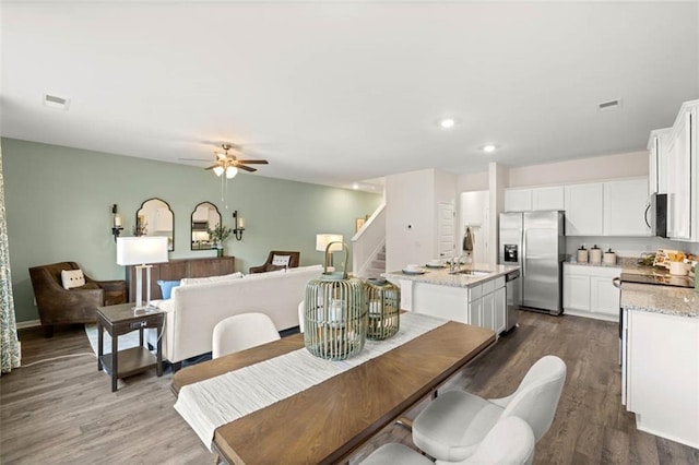 353 Sound Cir, Stockbridge, GA 30281 - dining space featuring ceiling fan, dark wood-type flooring, stairs, and visible vents