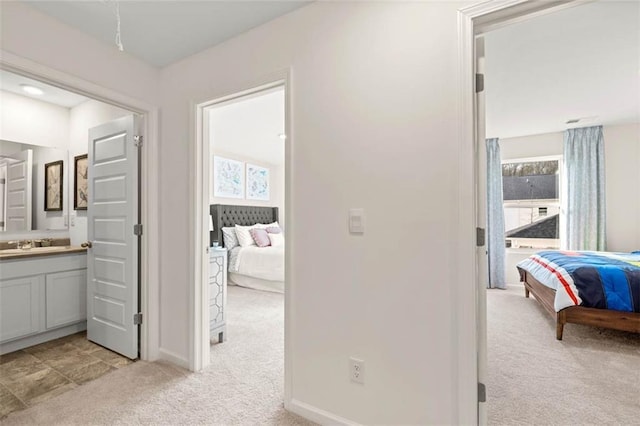 353 Sound Cir, Stockbridge, GA 30281 - hall with light carpet, a sink, and baseboards