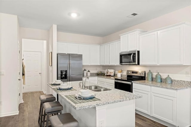 353 Sound Cir, Stockbridge, GA 30281 - kitchen with white cabinets, stainless steel appliances, a sink, visible vents, and light stone counters
