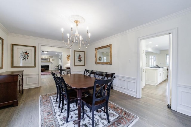 dining space featuring hardwood / wood-style flooring, crown molding, and a notable chandelier