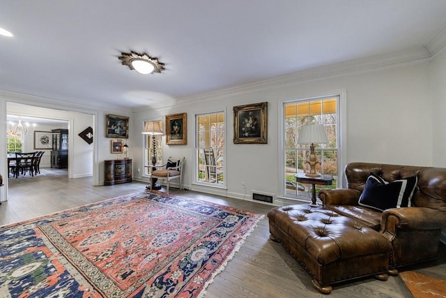 living room with a chandelier, crown molding, and hardwood / wood-style flooring