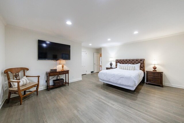 bedroom with light hardwood / wood-style flooring and crown molding