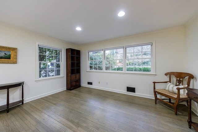 living area with dark hardwood / wood-style flooring and ornamental molding