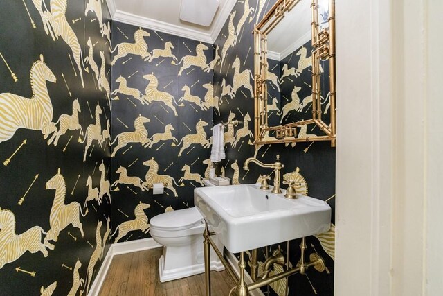 bathroom featuring toilet, sink, ornamental molding, and hardwood / wood-style flooring