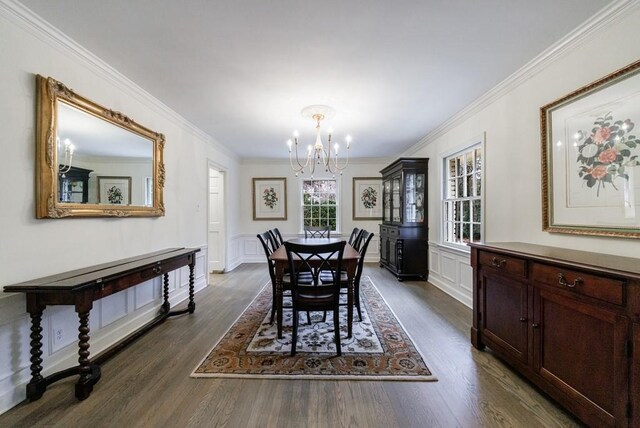 dining space featuring dark hardwood / wood-style flooring, a chandelier, and ornamental molding