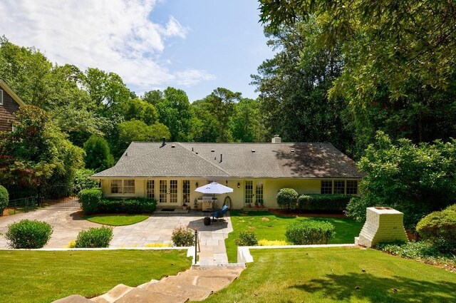 back of house with french doors, a patio, and a yard