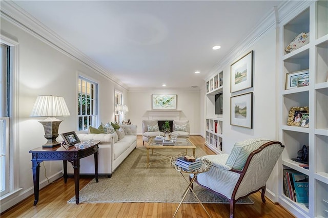 living room with ornamental molding, built in features, and hardwood / wood-style flooring