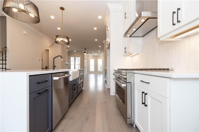 530 Fisher Dr Unit 45, Alpharetta, GA 30009 - kitchen featuring stainless steel appliances, wall chimney exhaust hood, light wood finished floors, decorative backsplash, and white cabinetry