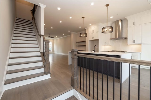 530 Fisher Dr Unit 45, Alpharetta, GA 30009 - kitchen with wall chimney range hood, light wood-type flooring, white cabinetry, light countertops, and ornamental molding