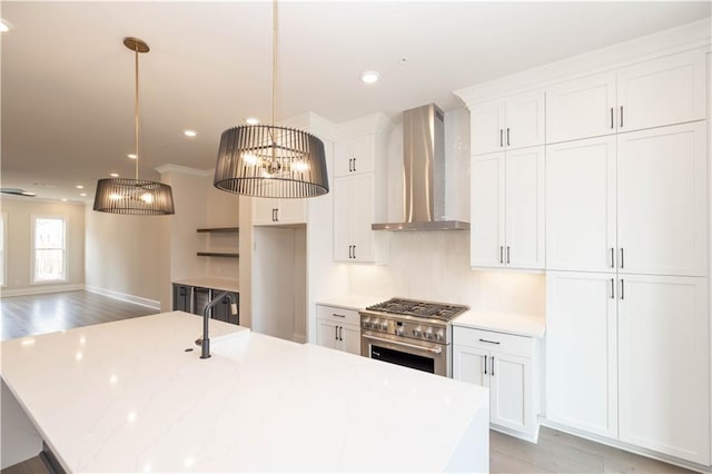 530 Fisher Dr Unit 45, Alpharetta, GA 30009 - kitchen featuring wall chimney exhaust hood, high end stainless steel range, an island with sink, white cabinetry, and hanging light fixtures