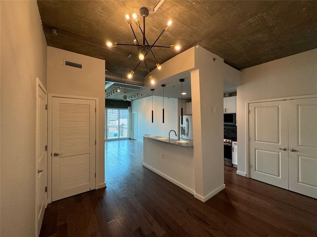 kitchen featuring white cabinets, hanging light fixtures, dark hardwood / wood-style floors, stainless steel appliances, and a chandelier