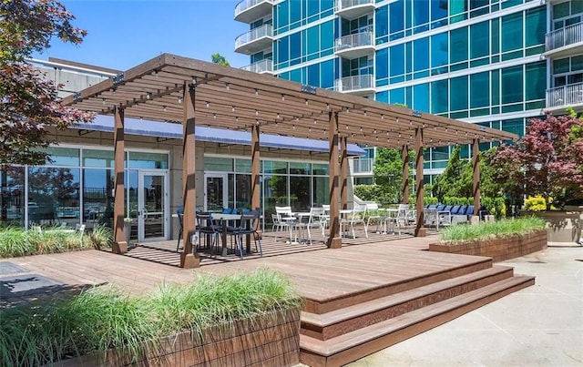 view of community featuring a pergola and a wooden deck