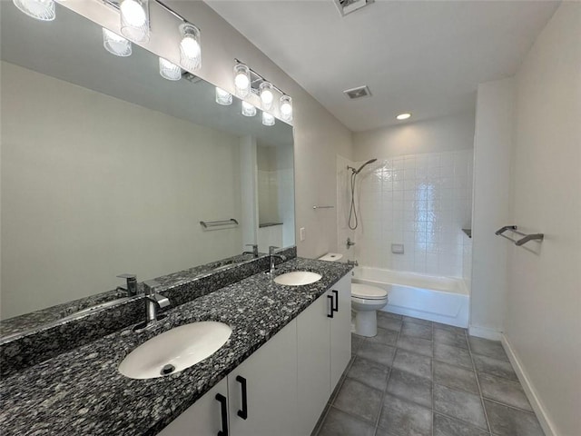 full bathroom featuring tile patterned floors, vanity, tiled shower / bath combo, and toilet