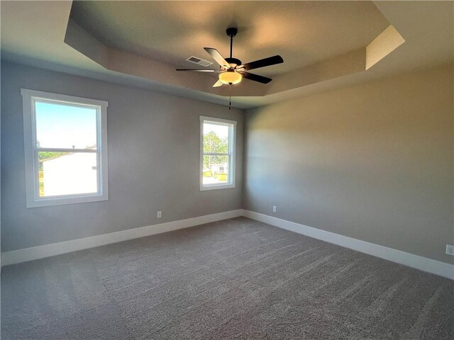 spare room featuring ceiling fan, carpet floors, and a raised ceiling