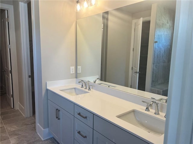 bathroom featuring tiled shower and vanity