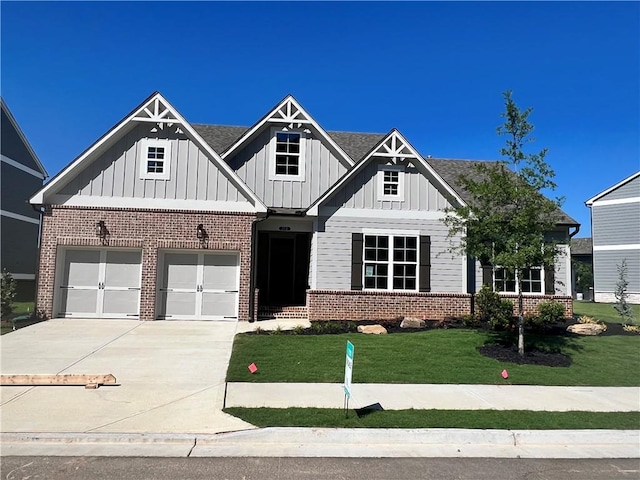 craftsman inspired home with a garage and a front lawn