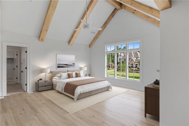 bedroom featuring visible vents, light wood-style floors, connected bathroom, high vaulted ceiling, and beamed ceiling