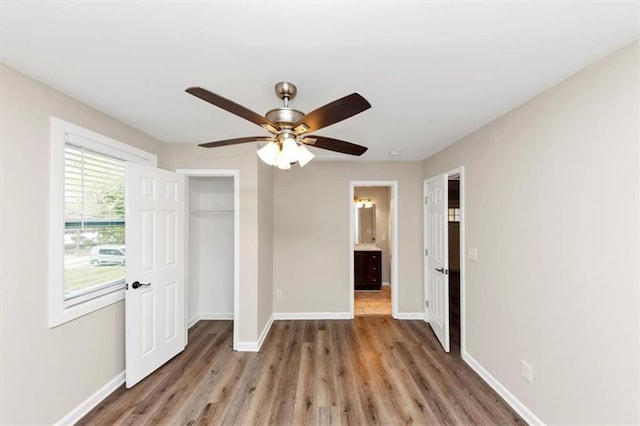 unfurnished bedroom with a closet, a ceiling fan, baseboards, and wood finished floors