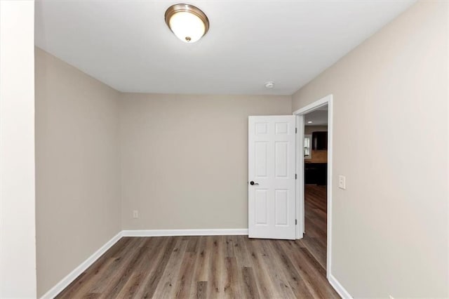 empty room with baseboards and wood finished floors