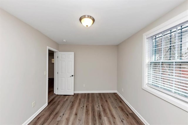 unfurnished room with baseboards and wood finished floors