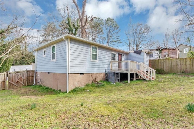 back of house featuring stairway, a yard, fence, and crawl space