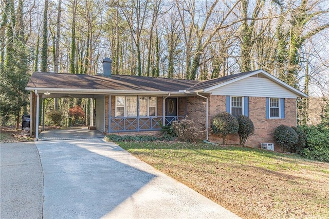 ranch-style home featuring a porch, a front yard, and a carport