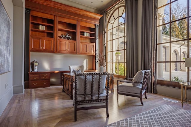 office space with built in study area and wood finished floors