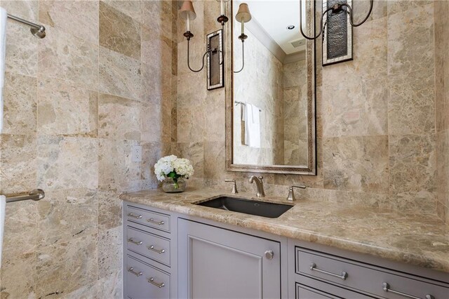 bathroom featuring vanity and tile walls