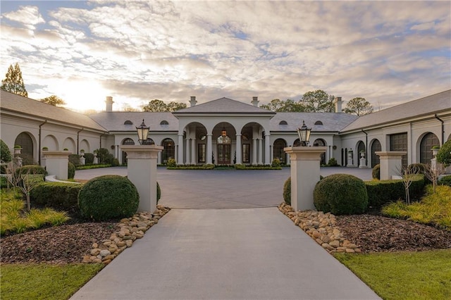 mediterranean / spanish-style house with curved driveway and a garage
