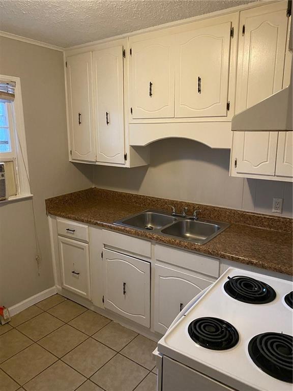 kitchen featuring white cabinetry, a sink, and electric range