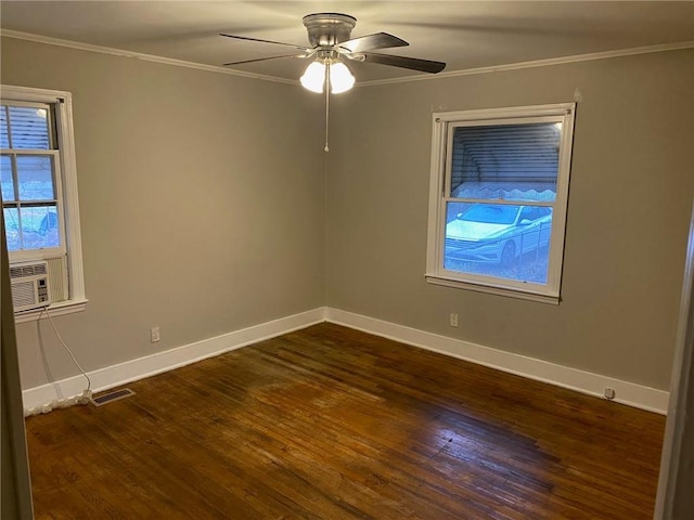 empty room with dark wood finished floors, crown molding, visible vents, ceiling fan, and baseboards