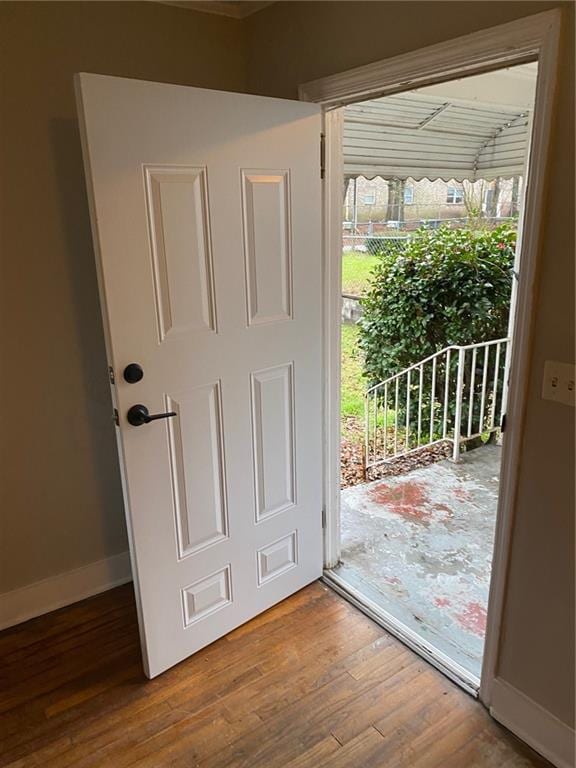 doorway to outside with baseboards and wood finished floors