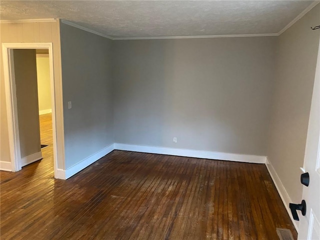 empty room with wood-type flooring, ornamental molding, and baseboards