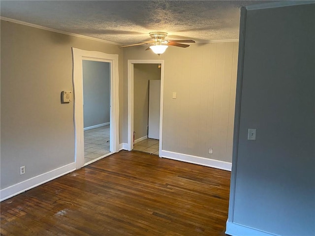 spare room featuring ornamental molding, ceiling fan, a textured ceiling, and wood finished floors