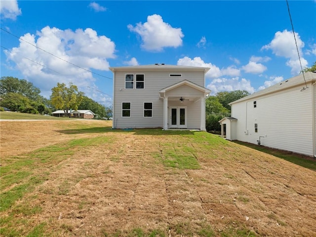 rear view of house with ceiling fan, a yard, and french doors