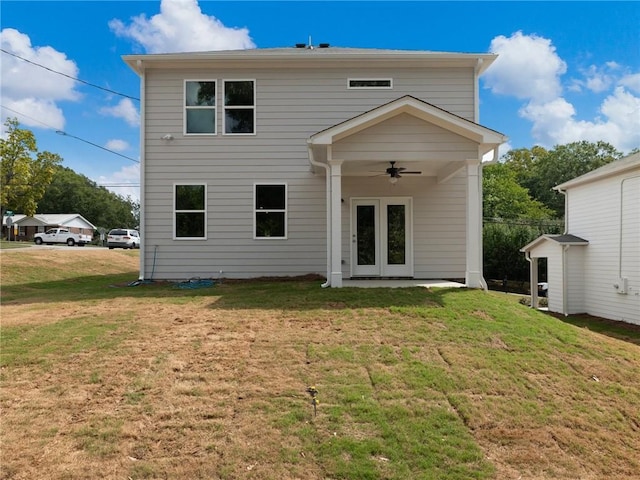 rear view of property featuring ceiling fan and a lawn