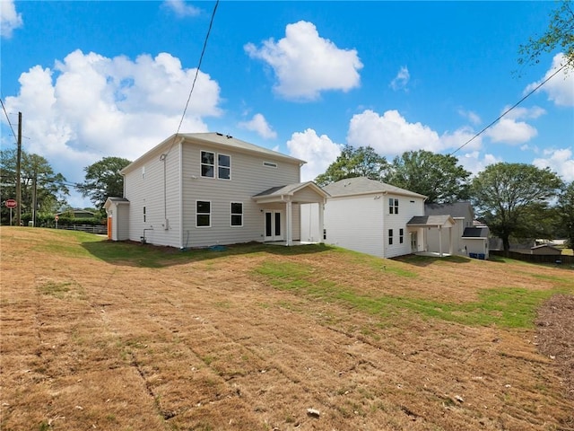 back of property featuring a yard