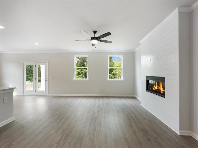 unfurnished living room with ceiling fan, dark hardwood / wood-style flooring, ornamental molding, and a fireplace